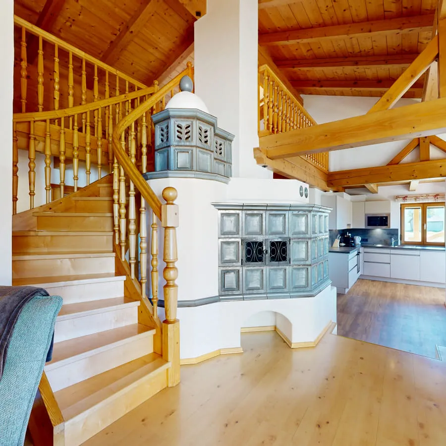 Innenansicht mit Treppe, Kamin und offenem Wohnbereich