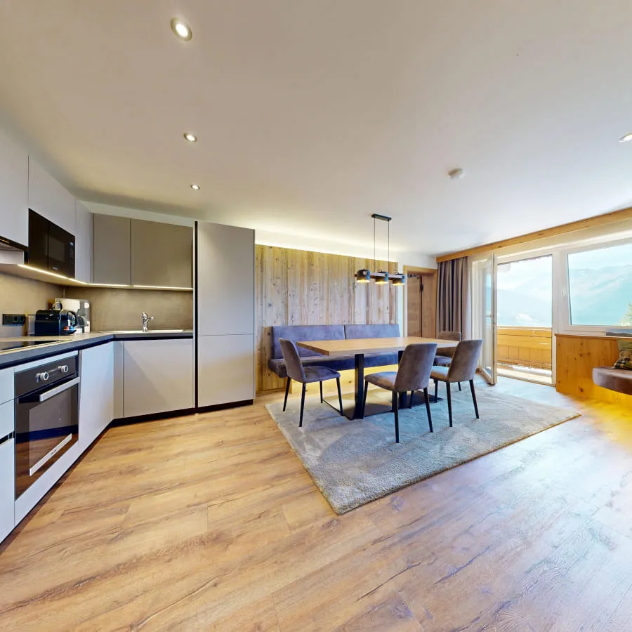 Moderne Wohnung mit Küche, Essbereich und Panoramablick auf die Berge.