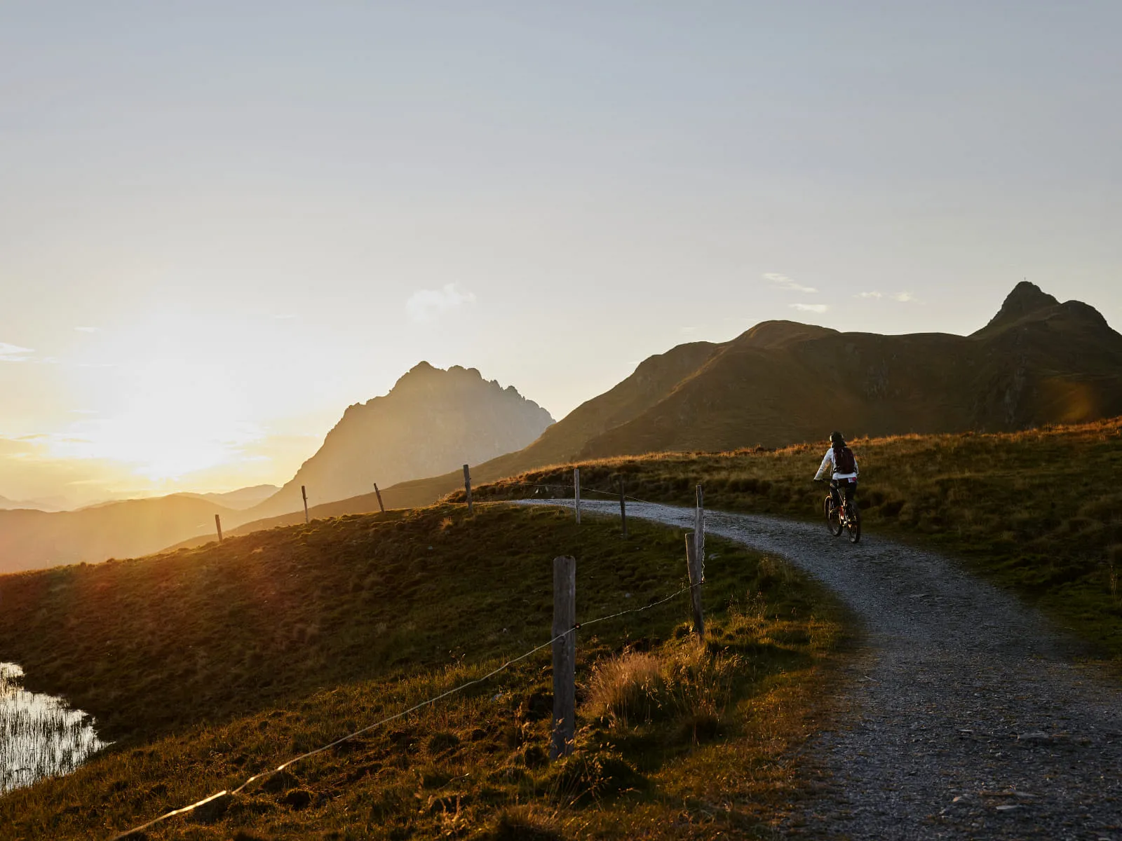 Radfahrer auf einem Weg in Mittersill bei Sonnenuntergang