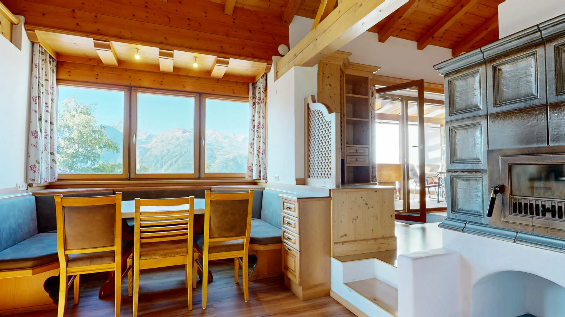 Holzinterieur mit Sitzgelegenheiten und Kamin, Aussicht auf die Berge