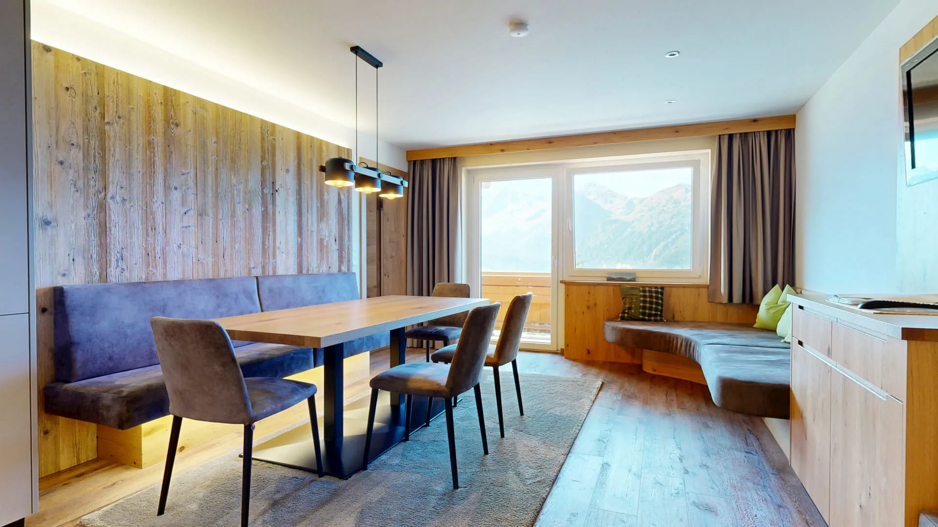 Innenansicht eines modernen Wohnraums mit Holzdekor und Aussicht auf die Berge