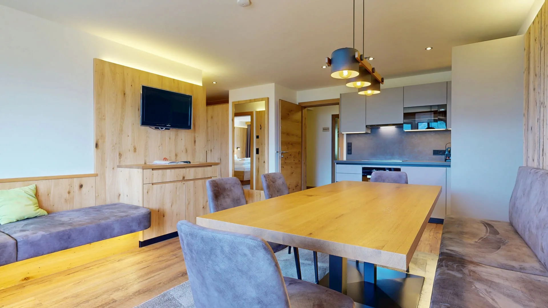 Moderne Wohnküche mit Holzdetails, Esstisch und Fernseher