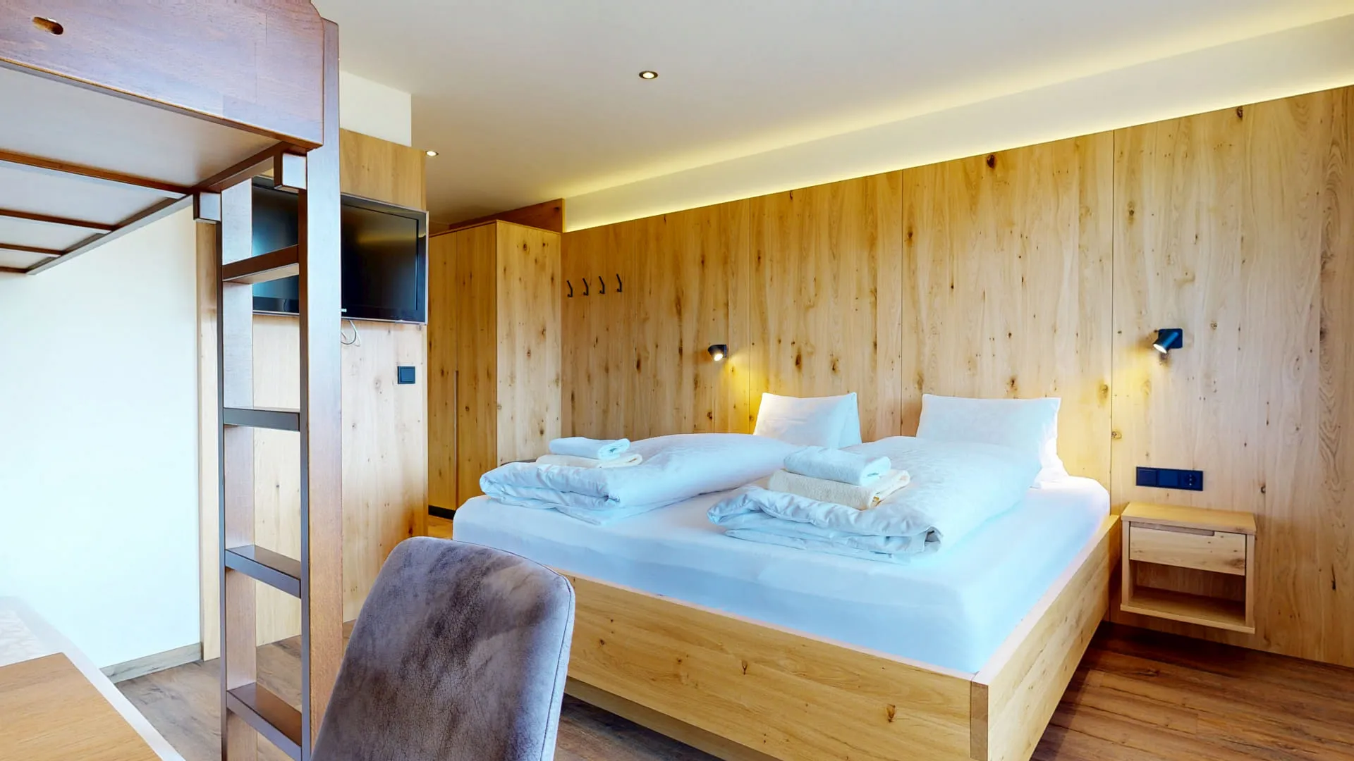 Helles Schlafzimmer mit Holzdetails und Bettwäsche auf einem Holzbett.