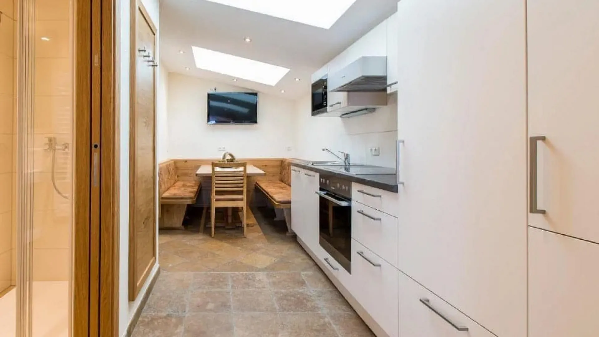 Moderne Küche mit Holzdetails, Essbereich und TV