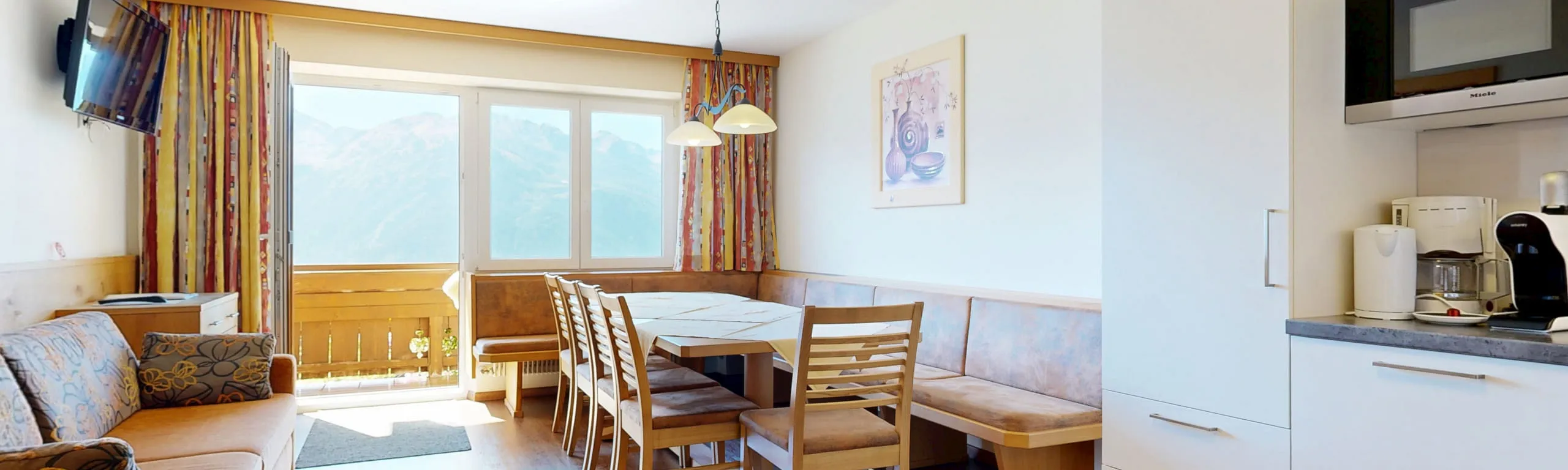 Helles Wohn- und Esszimmer mit Aussicht auf die Berge und moderner Küchenecke