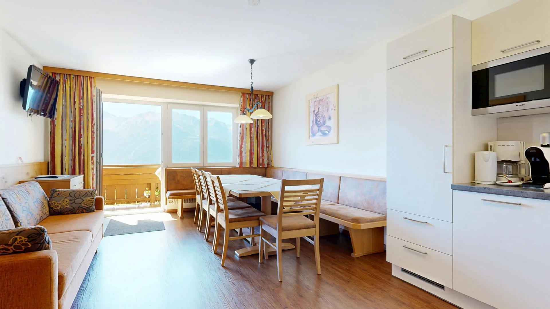 Wohnzimmer mit Esstisch, Sofa und Küchenecke mit Blick auf die Hohe Tauern