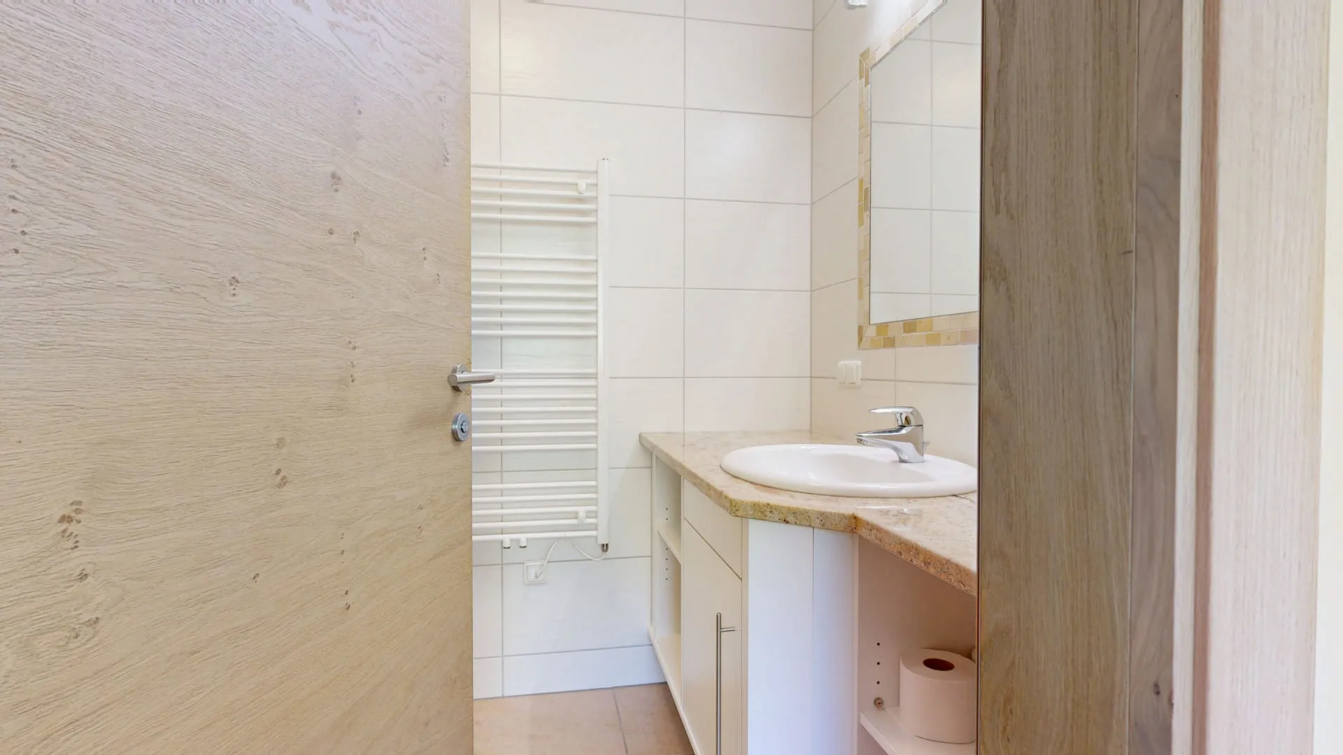 Badezimmer mit Holzdetails, Waschbecken und Handtuchheizkörper.