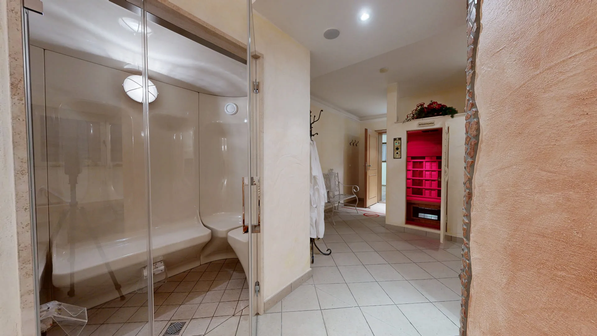 Wellnessbereich mit Glasdusche, Wanne und gemütlichem Ambiente.